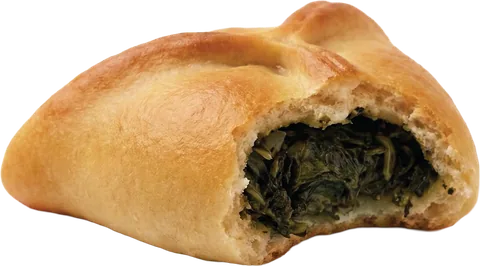 A spinach pie bitten open to show the spinach filling