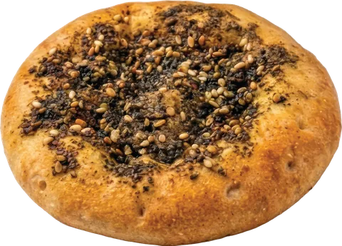 A zaatar pie seen from the side, golden at the edges