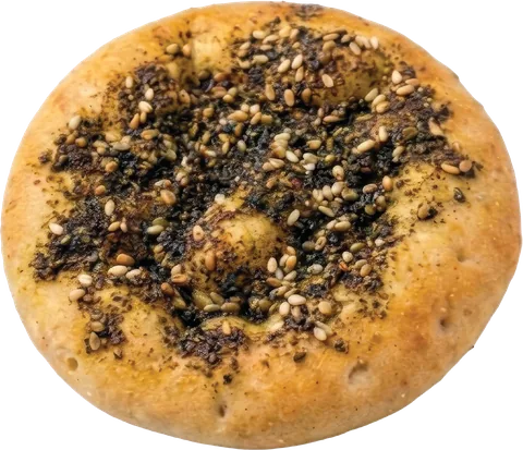 A golden zaatar pie (zaatar manakish) topped with zaatar and sesame seeds